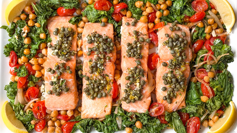 1-pan baked salmon with mustard greens and chickpeas on serving platter with lemon wedges