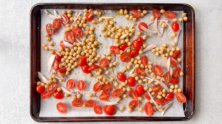 Chickpeas, grape tomatoes, shallot, and rosemary on parchment-lined baking sheet