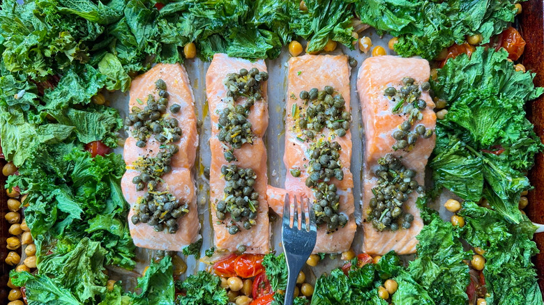 1-pan baked salmon with mustard greens and chickpeas on baking sheet