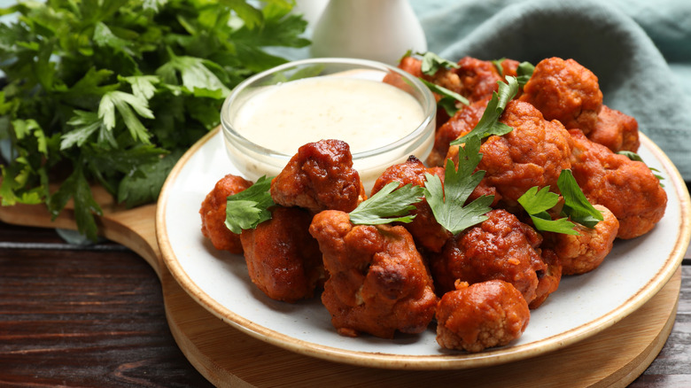 Plate of buffalo cauliflower with a bowl of ranch and parsley