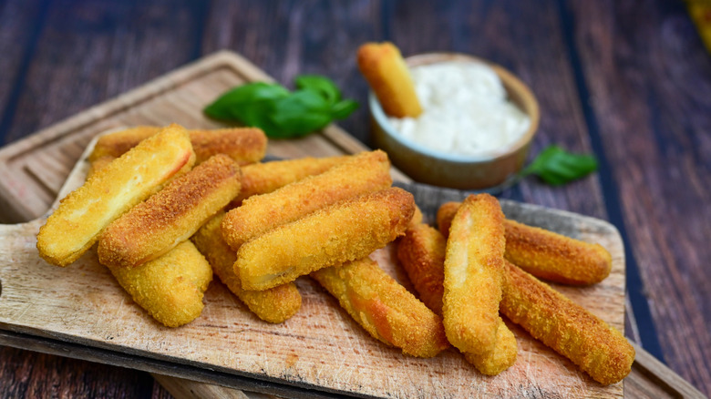 Pile of mozzarella sticks and a bowl of ranch