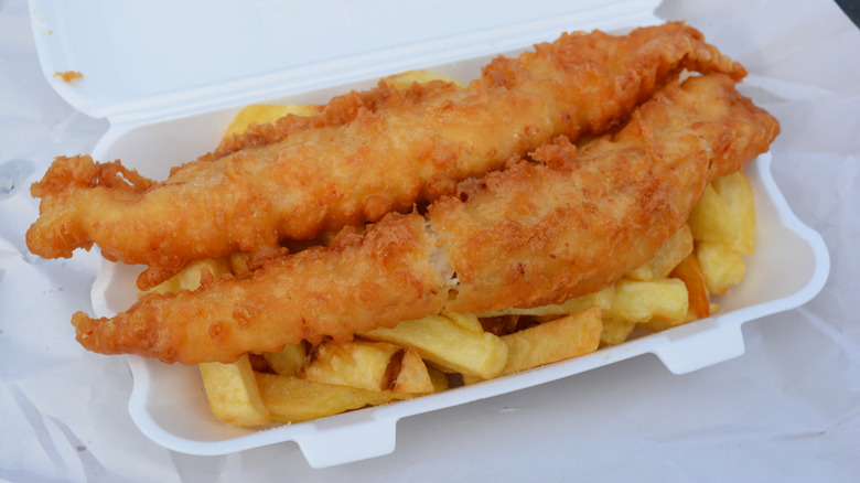 white foam to-go container filled with fish and chips