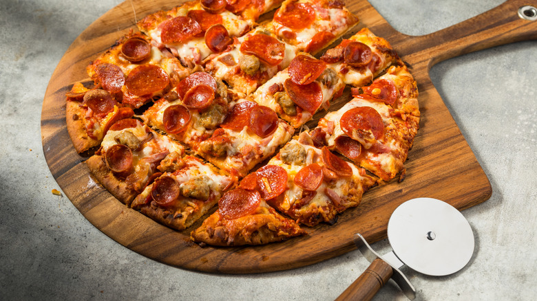 round tavern style pizza on cutting board