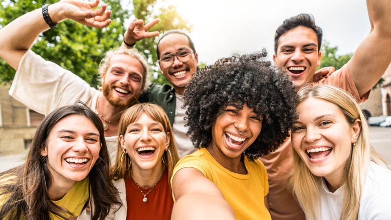 Group of multicultural friends smiling and taking a group selfie