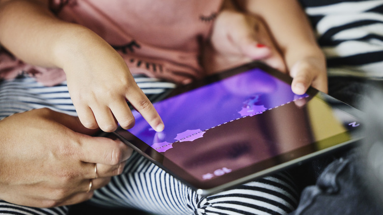 Closeup of young girl playing with tablet