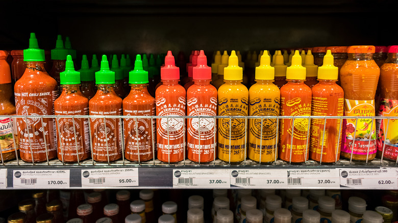 Shelf with different brands of sriracha sauce