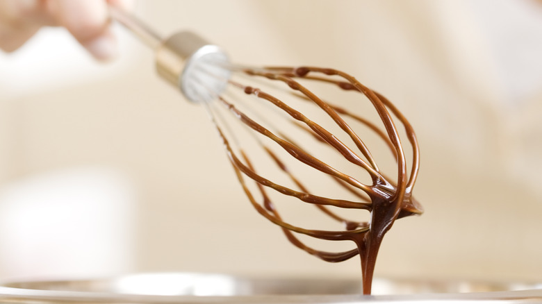 A whisk covered in hot chocolate