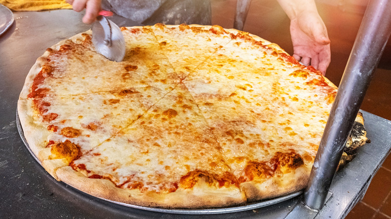 cutting giant New York pizza