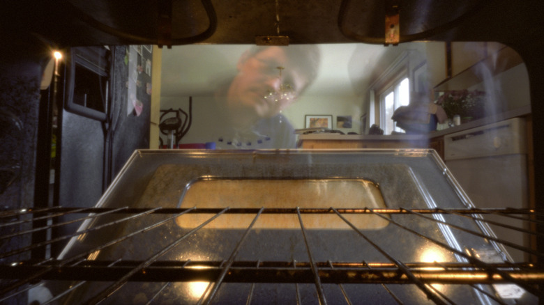 Man peeking into open oven