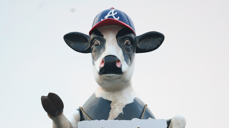 Giant Chick-fil-A cow looks over Atlanta Braves stadium.