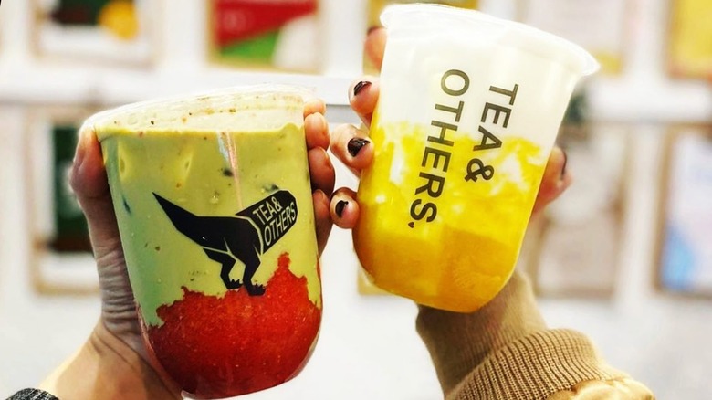 Two hands holding bubble teas from Tea & Others, in San Francisco