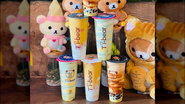 Stacked Tibear bubble tea cups in front of stuffed animals