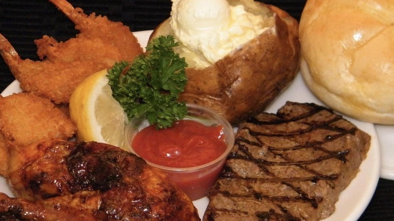 steak, chicken, fried shrimp, and loaded baked potato on a plate