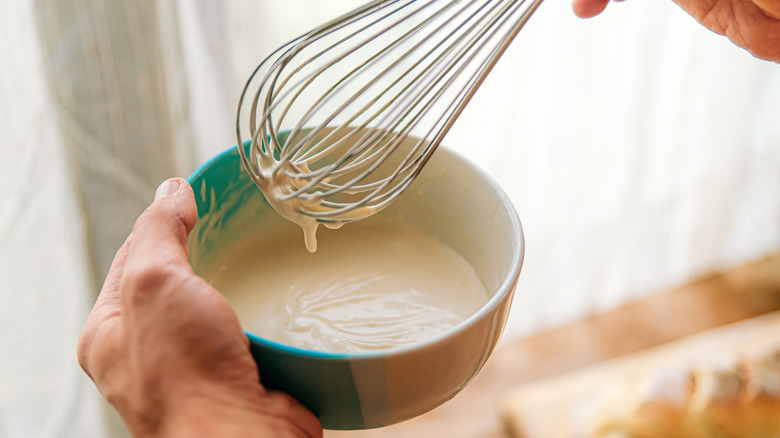 man whisking sauce together