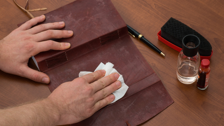 Person wiping leather book cover