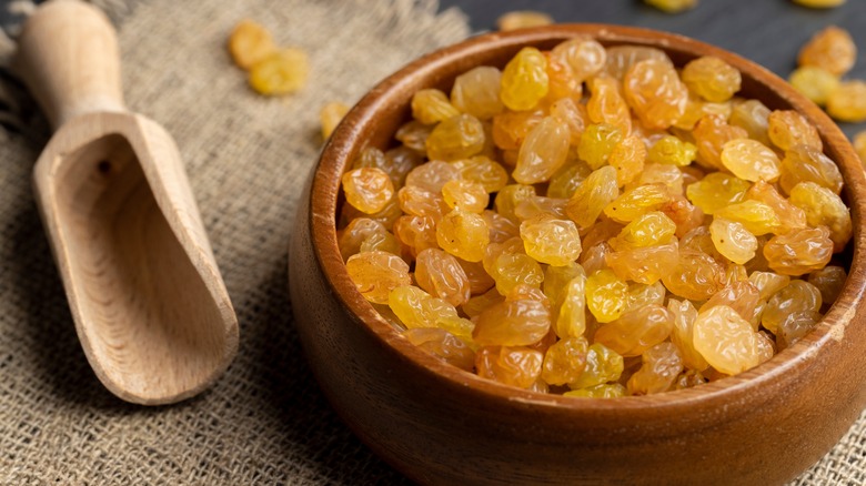 Wooden bowl full of golden raisins