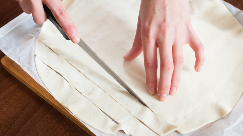 A person cutting store-bought pastry