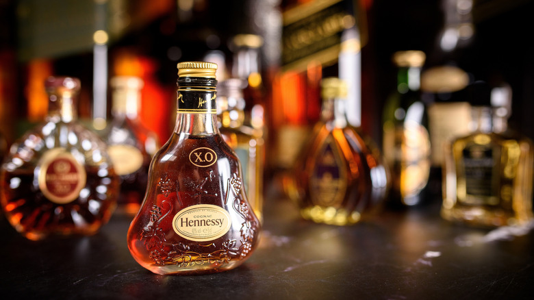 Bottles of Hennessy with other liquor bottles in background