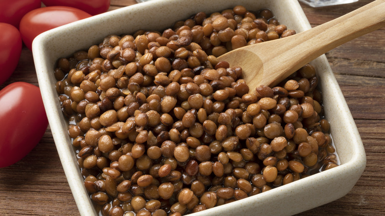 brown lentils, wooden spoon