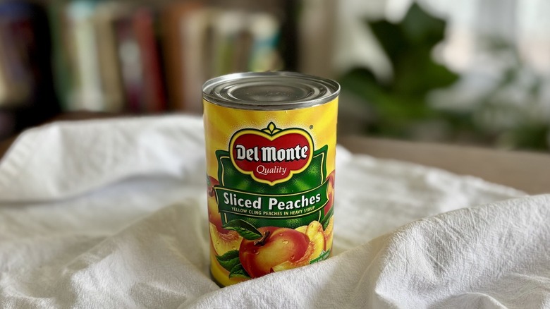 Del Monte Canned Sliced Peaches on table in front of shelf