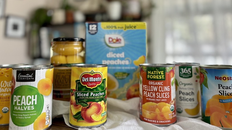 canned peaches arranged on a table in front of window
