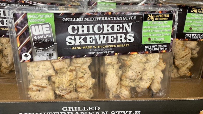 A package of grilled chicken skewers in the display box on the shelf at Costco