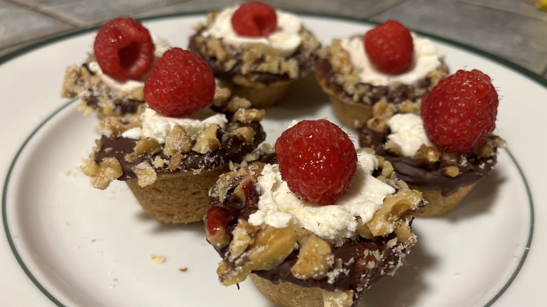 A plate of million-dollar cookie cups with raspberries
