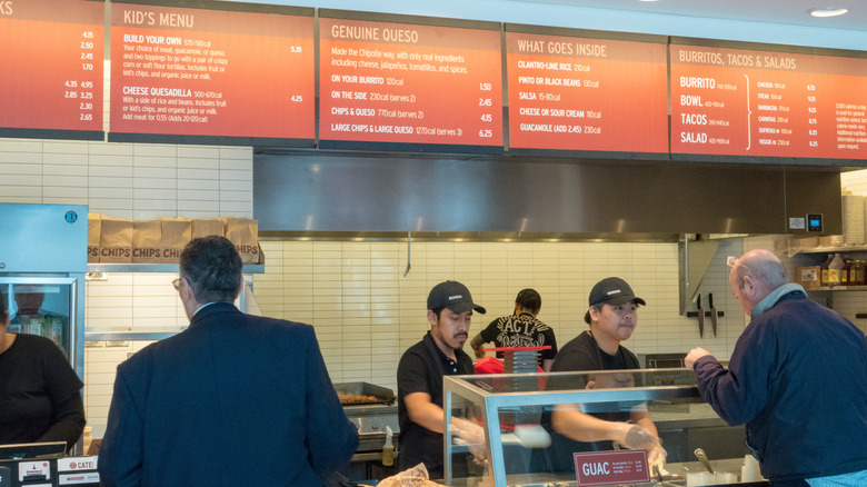 The inside of a Chipotle, with customers ordering from workers at the counter