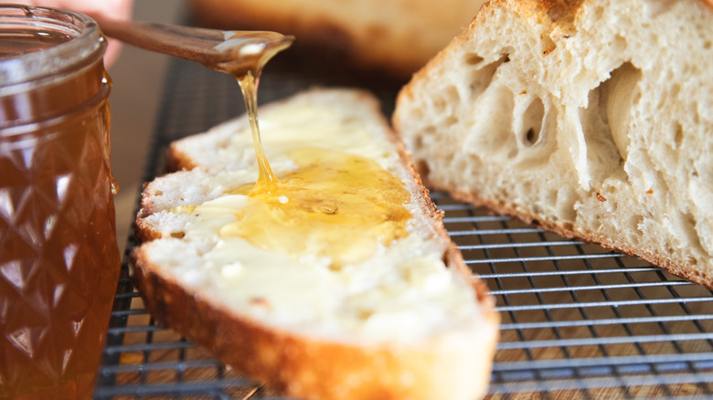 Sourdough bread with honey dripping on it from a spoon