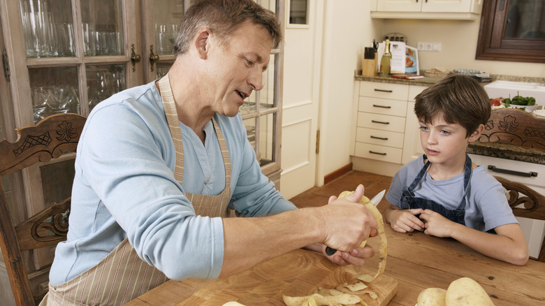 Father and son peeling potatoes
