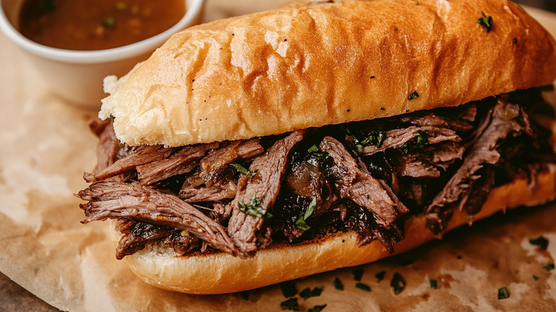 French dip sandwich with jus on white plate