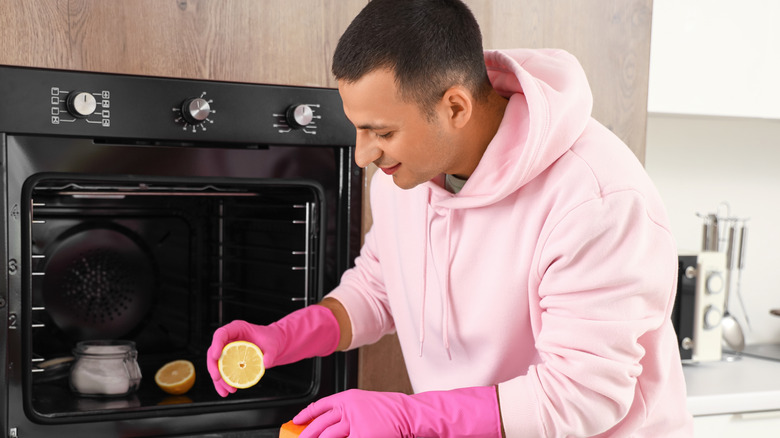 Person cleaning oven with lemon