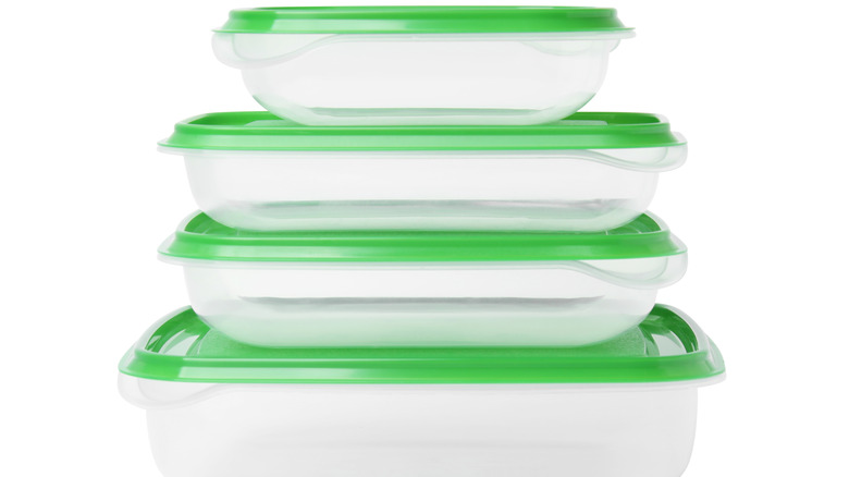 Three plastic containers, stacked with green lids