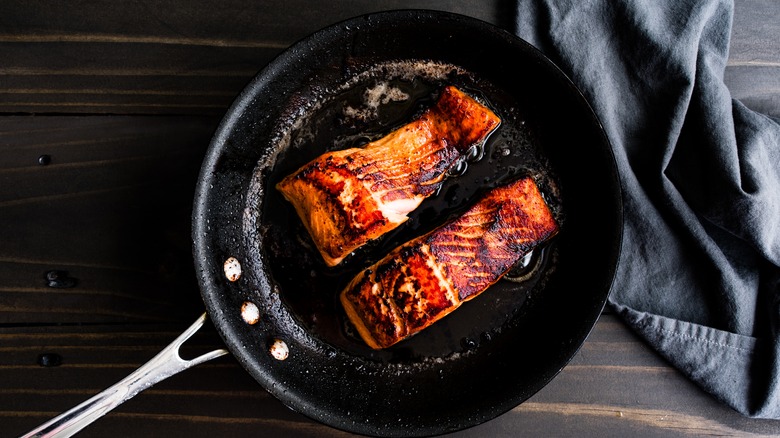 charred fish filets in frying pan