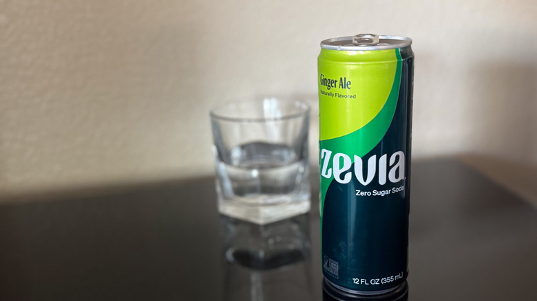 can of Zevia ginger ale with glass of clear ginger ale blurred in the background