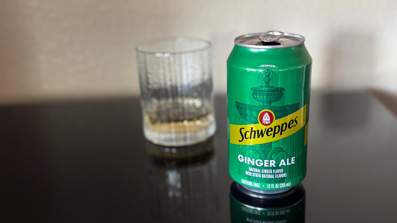 can of Schweppes Ginger Ale next to an out-of-focus glass