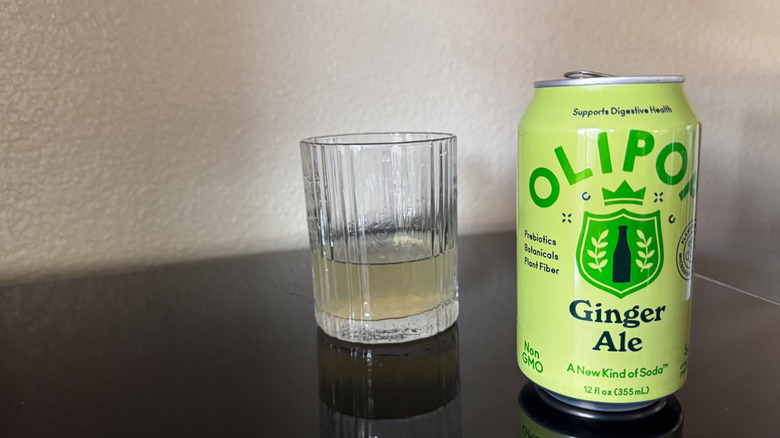 Olipop Ginger Ale can next to a glass of ginger ale