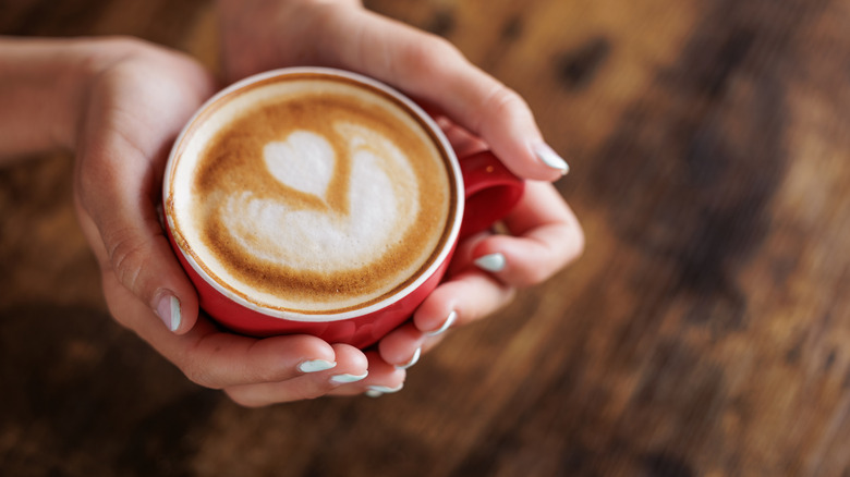 Latte with milk art in red mug