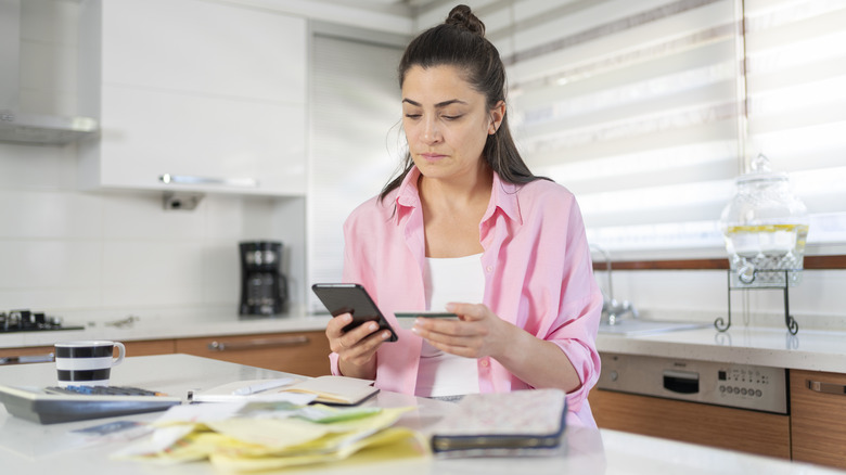 Woman paying bills in a kitchen