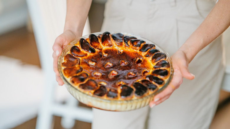 Woman holding burnt baked good