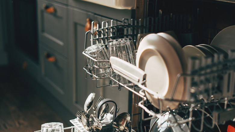 Open dishwasher with clean utensils in it