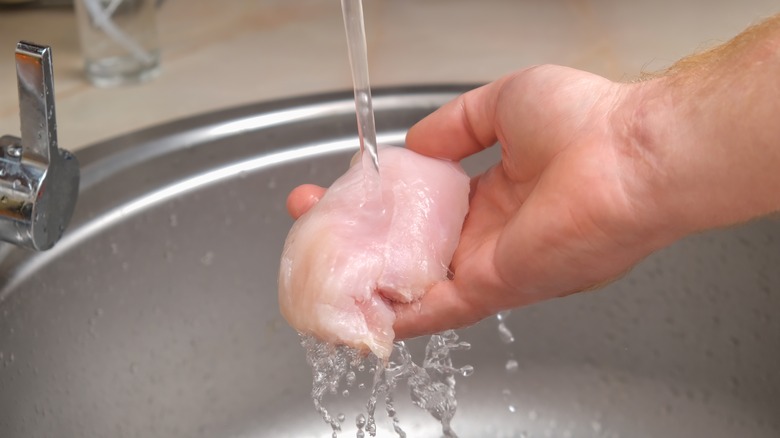 washing chicken filet in sink