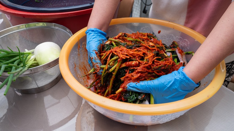 Woman mixing kimchi ingredients together