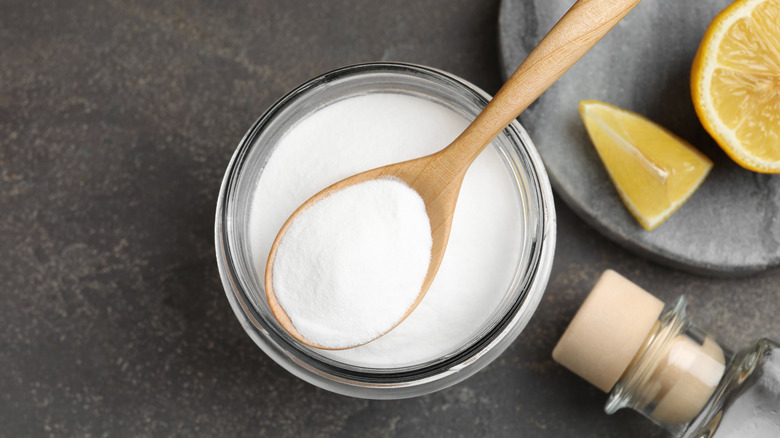 wooden spoonful of baking soda over glass jar