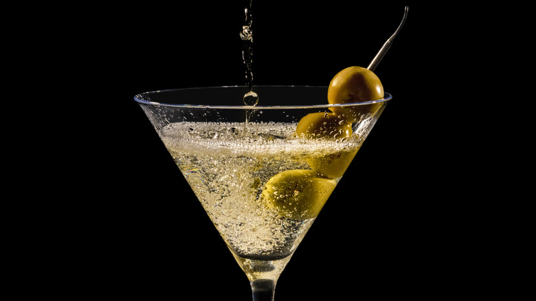 pouring a martini with olives