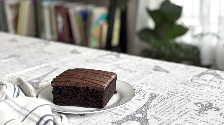 A square-shaped slice of Walmart Freshness Guaranteed Chocolate Cake on table with Paris-themed tablecloth