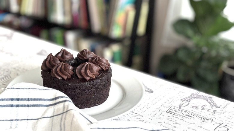 A whole Simple Truth Gluten-Free Double Chocolate Cake on a table next to a kitchen towel