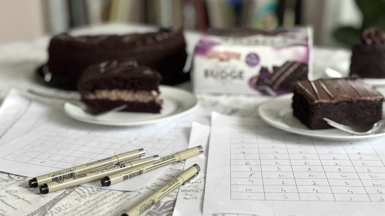 scoresheets and pens on table with chocolate cakes