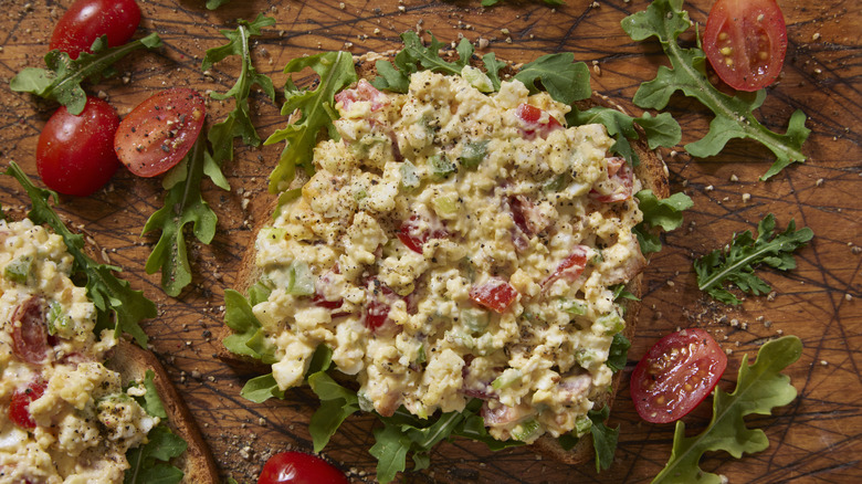 egg salad with tomatoes and arugula on bread