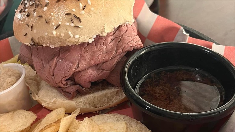 A beef sandwich with au jus dip